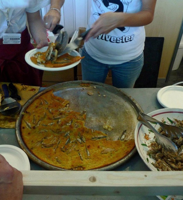 Anchovy Farinata is immediately cut and served to the participants of the Slow Fish who had been waiting patiently.